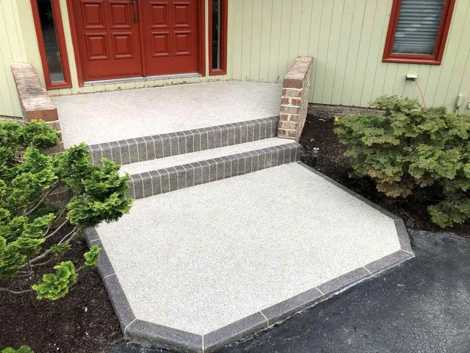 Front porch with brick steps and plants.