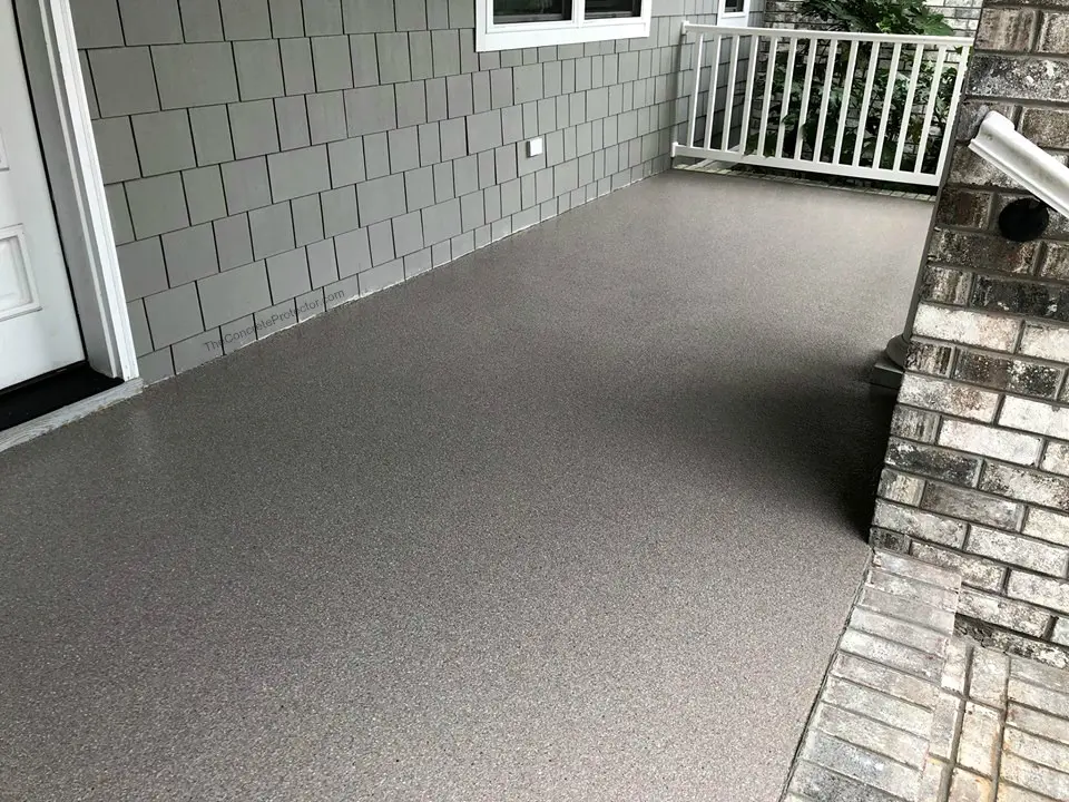Gray textured patio with white railing.