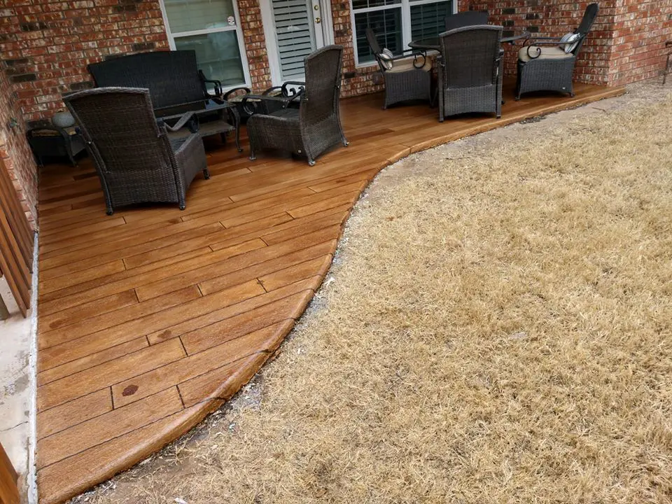 Patio with wicker furniture and dry grass.
