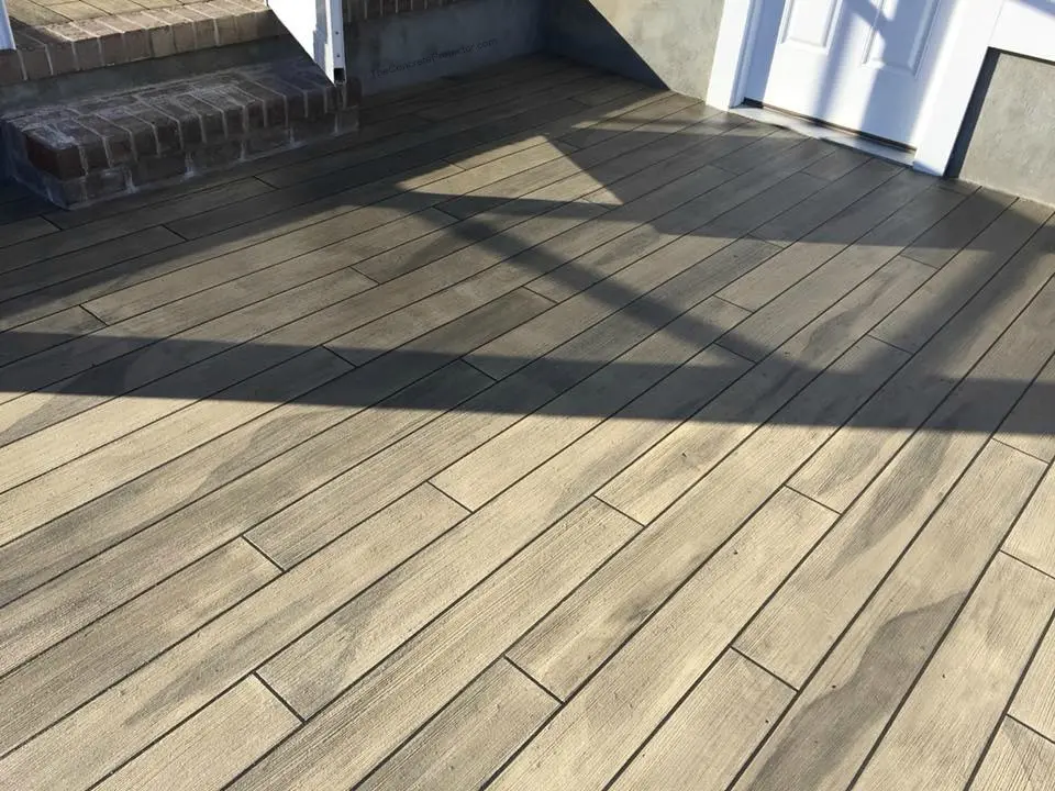 Wood-patterned outdoor tile flooring with shadows.