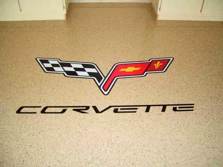 Corvette logo on speckled garage floor.