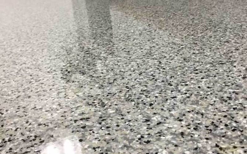 Speckled gray epoxy floor in room.