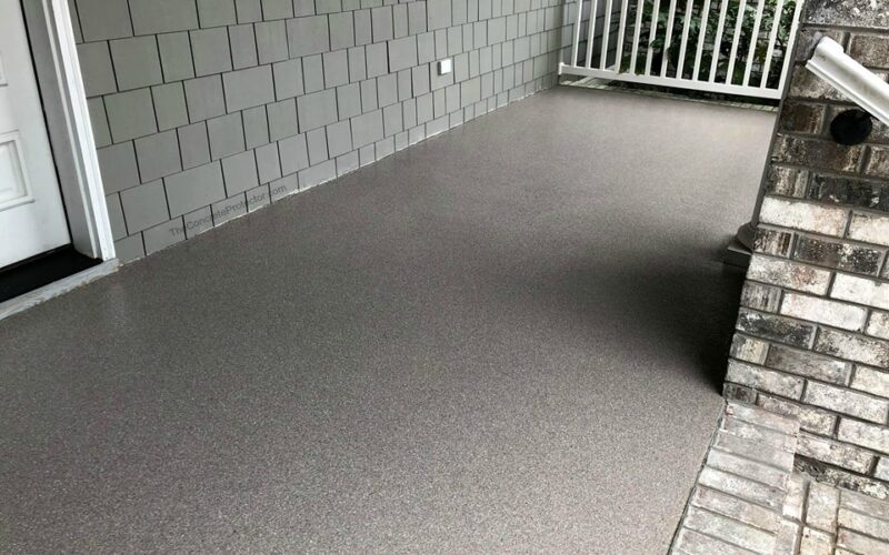 Gray textured patio with white railing.