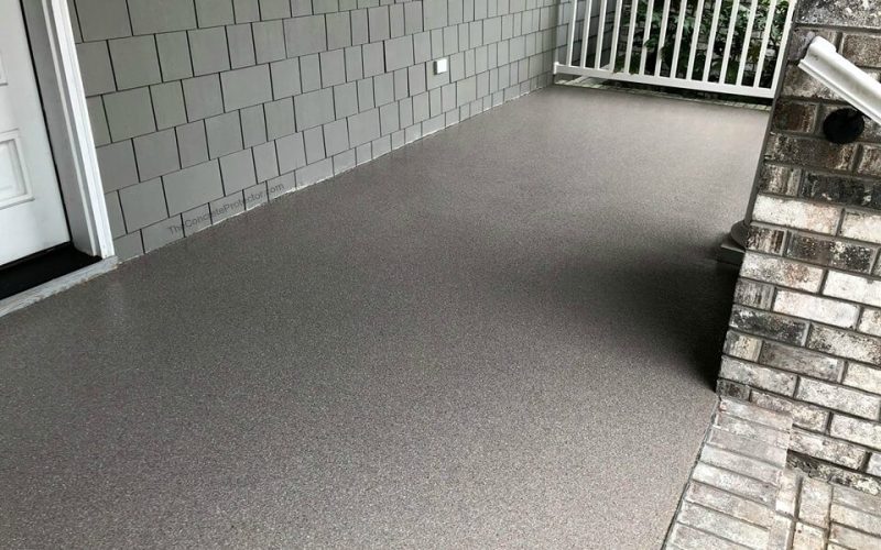 Gray textured patio with white railing.