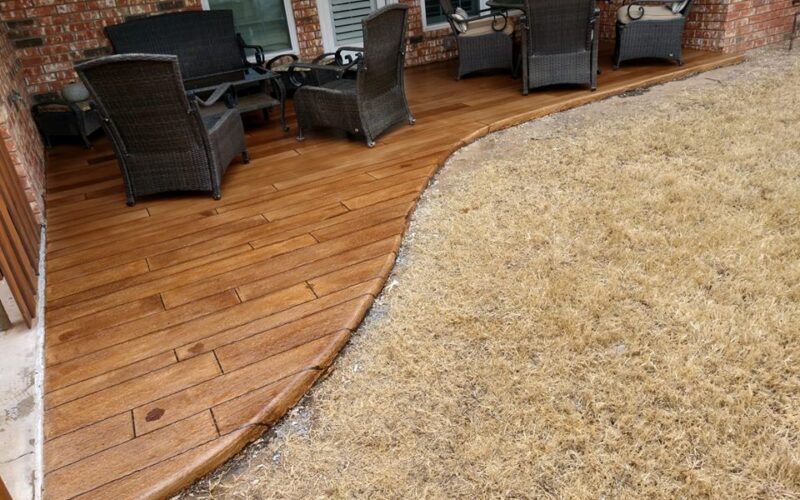 Patio with wicker furniture and dry grass.