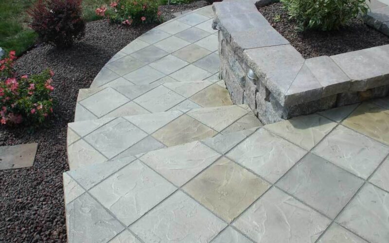 Stone patio with steps and surrounding plants.