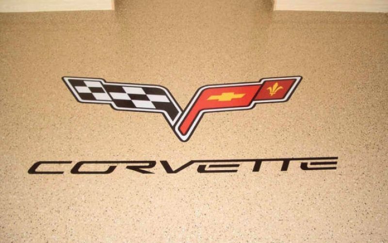 Corvette logo on speckled garage floor.