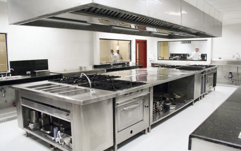 Commercial stainless steel kitchen with cooking equipment.
