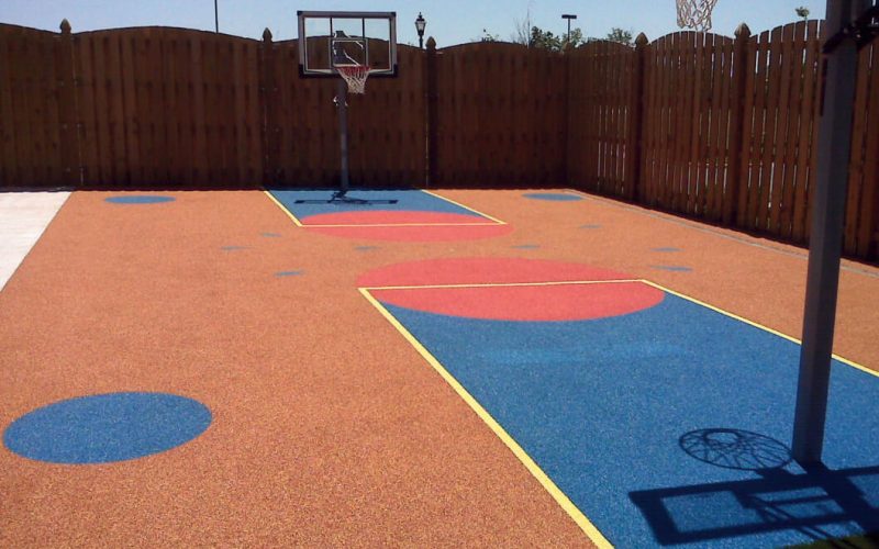 Colorful outdoor basketball court with geometric designs.